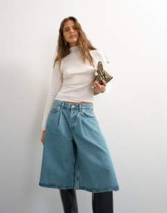 Model wearing X Cara denim ultra-wide pleated culotte in light green cast