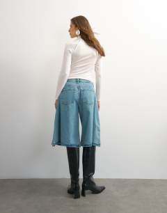 Model wearing X Cara denim ultra-wide pleated culotte in light green cast