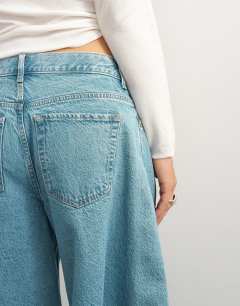 Model wearing X Cara denim ultra-wide pleated culotte in light green cast