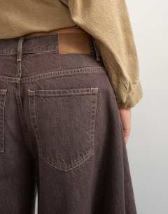 Model wearing X Cara denim ultra-wide pleated culotte in taupe