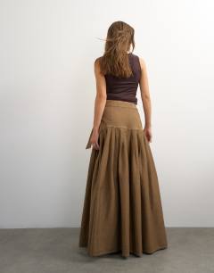 Model wearing X Cara denim waterfall drape pleated skirt in camel