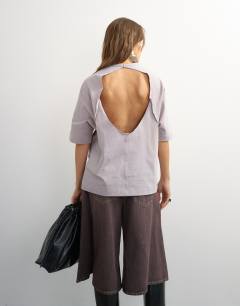 Model wearing Topshop X Cara open back tee in grey