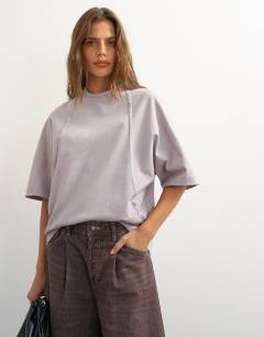 Model wearing Topshop X Cara open back tee in grey