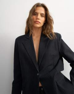 Model wearing Topshop X Cara oversized pinstripe denim co-ord blazer in indigo