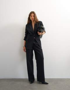 Model wearing Topshop X Cara oversized pinstripe denim co-ord blazer in indigo