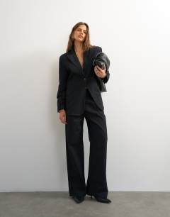 Model wearing X Cara wide leg pleated pinstripe denim co-ord trouser in indigo
