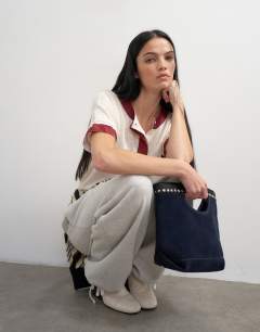 Model wearing Topshop x Talia Byre premium real suede studded grab bag in navy