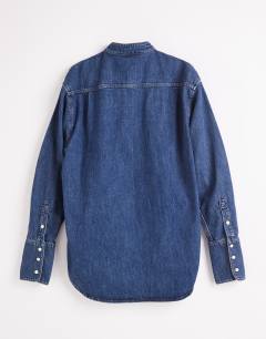 Model wearing Topshop x Talia Byre wide placket studded shirt in washed blue