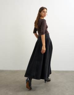 Model wearing Yoke pleated maxi skirt in washed black