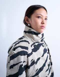 Model wearing Zebra print funnel neck trench coat in black