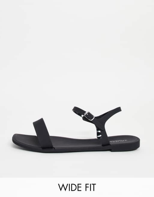 Truffle Collection – Flache Jelly-Sandalen in Schwarz und weiter Passform