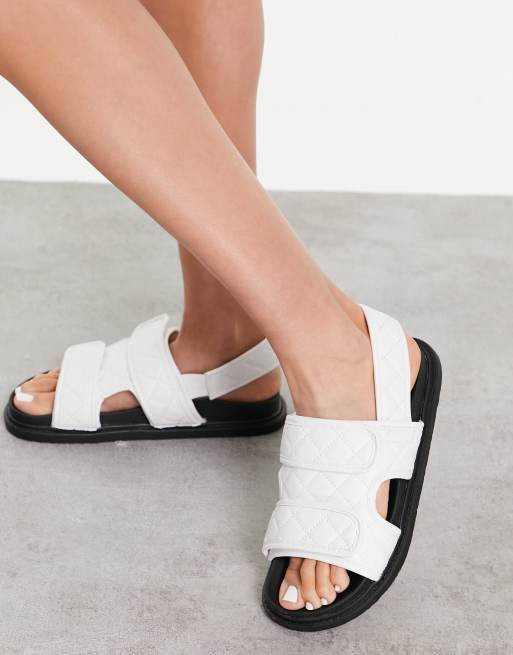 Truffle Collection – Vita, platta sandaler med dubbla, kviltade remmar
