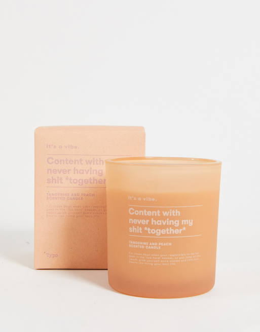 Typo candle jar with 'content' slogan in tangerine and peach scent