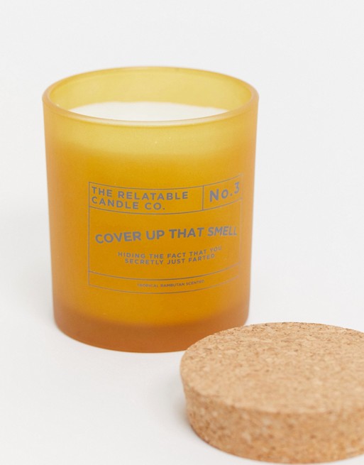 Typo candle with slogan 'cover up that smell' in yellow