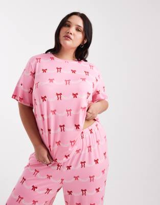 Urban Threads Urban Threads Curve Christmas short sleeve revere and trouser pyjama set in festive bow print-Pink