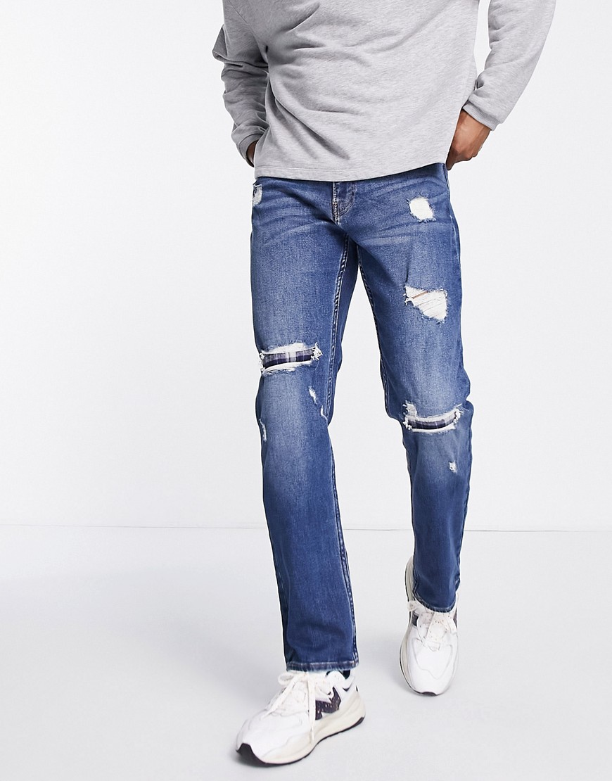 фото Узкие джинсы прямого кроя с рваной отделкой и заплатками из фланели темного выбеленного цвета hollister-темно-синий