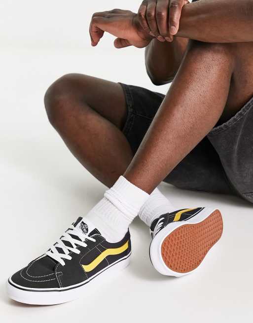 Black and yellow store low top vans