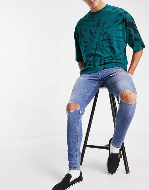 Vaqueros color azul medio lavado superajustados y elásticos con detalles rasgados de ASOS DESIGN