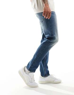 Vaqueros de corte tapered elástico con lavado azul medio vintage de ASOS DESIGN - view 1