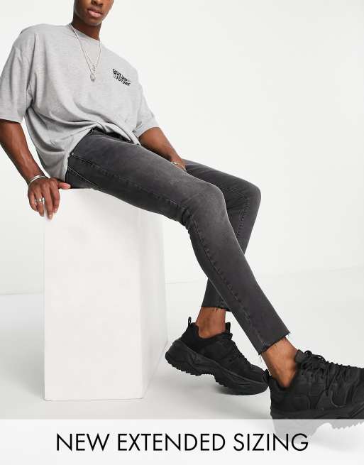 Vaqueros elásticos con lavado negro y bajos sin rematar de corte superpitillo de ASOS DESIGN