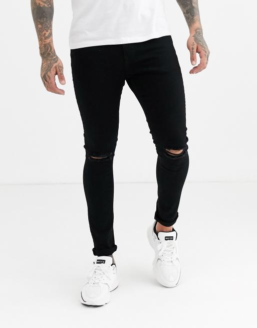 Vaqueros muy elásticos en negro con rotos en la rodilla Spray On de ASOS DESIGN