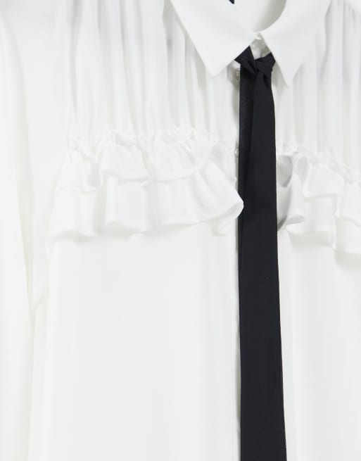 White ruffle blouse store with black tie