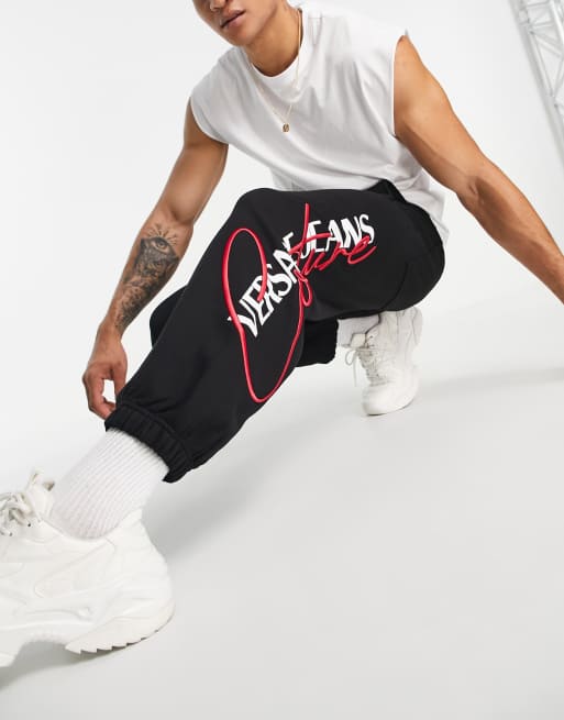 Versace Jeans Couture – Svarta mjukisbyxor i 90-talsstil med ikonisk logga