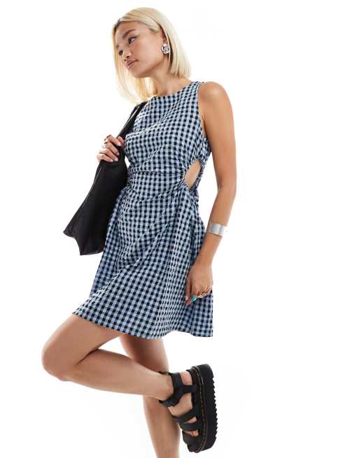 Vestido corto a cuadros vichy azul oscuro y negros sin mangas con laterales fruncidos y detalle de abertura de sirsaca de Monki