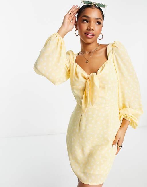 Vestido corto amarillo caléndula de manga larga con lazada en la parte delantera y estampado floral de The Frolic