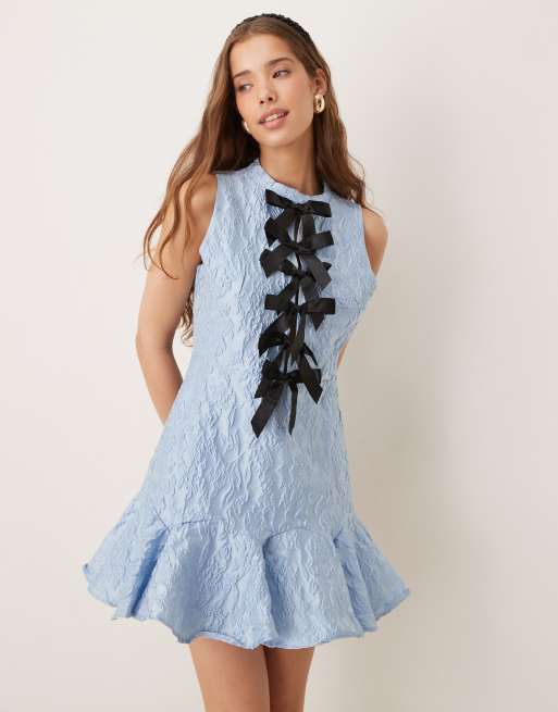 Vestido corto azul pastel con lazos en contraste y volantes en el bajo de Sister Jane