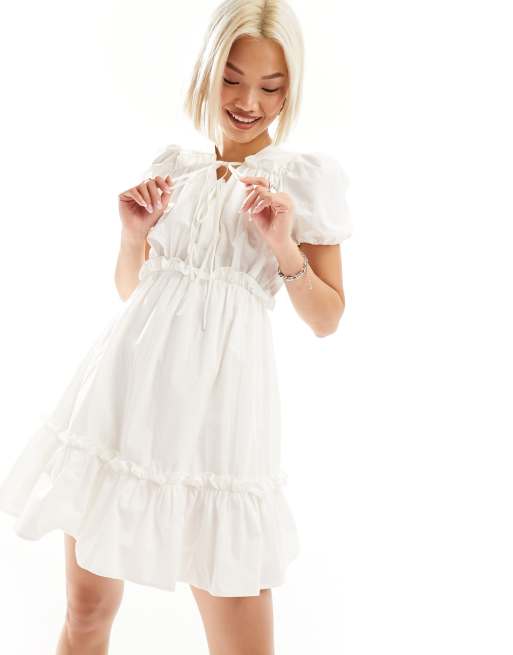 Vestido corto blanco con volantes y detalle de lazada de Urban Revivo