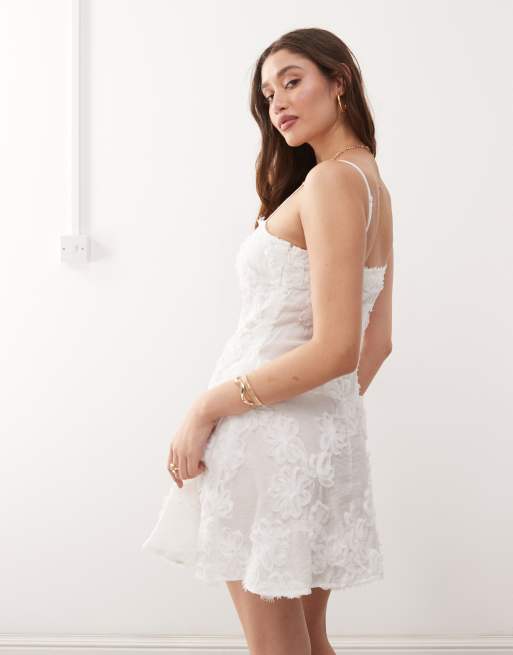 Vestido corto blanco de tirantes con estampado floral texturizado