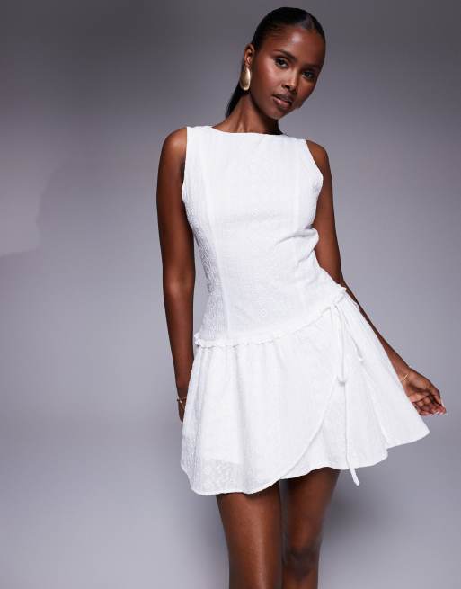 Vestido corto blanco sin mangas con diseño bordado, lazada delantera y volante en el bajo Cosie de Princess Polly