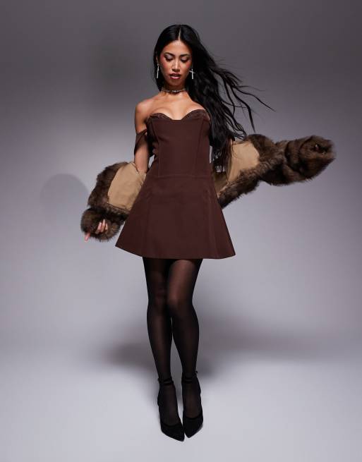 Vestido corto marrón chocolate con escote Bardot, cuerpo tipo corsé, cordones en la espalda y detalle fruncido en el pecho de Murci