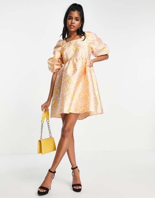 Vestido corto naranja con mangas abullonadas, bordado floral, espalda al aire y detalle de lazada premium de Pieces