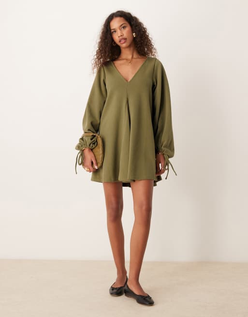 Vestido corto verde oliva con cuello de pico, bajo acampanado y lazadas en las mangas de punto muy suave de ASOS DESIGN