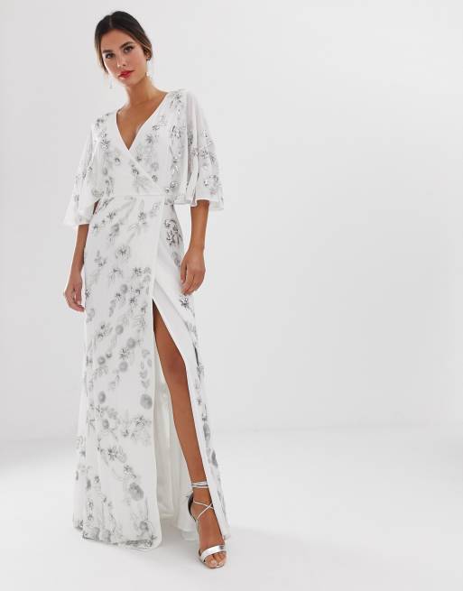 Vestido largo en blanco, cruzado en la parte delantera con adornos florales de Maya