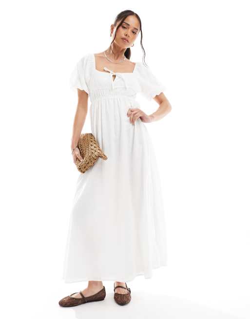 Vestido semilargo blanco hueso con mangas abullonadas, bordado inglés y detalle de lazada en el pecho de Daisy Street