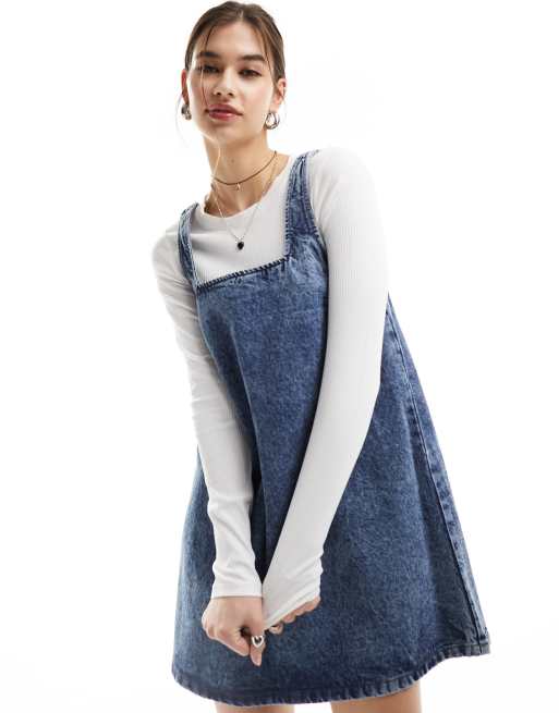 Vestido vaquero corto azul estilo peto con lavado ácido suave de Monki