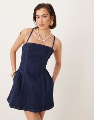 Vestido vaquero corto con lavado azul añil, cintura baja y tirantes cruzados en la espalda de Abercrombie & Fitch