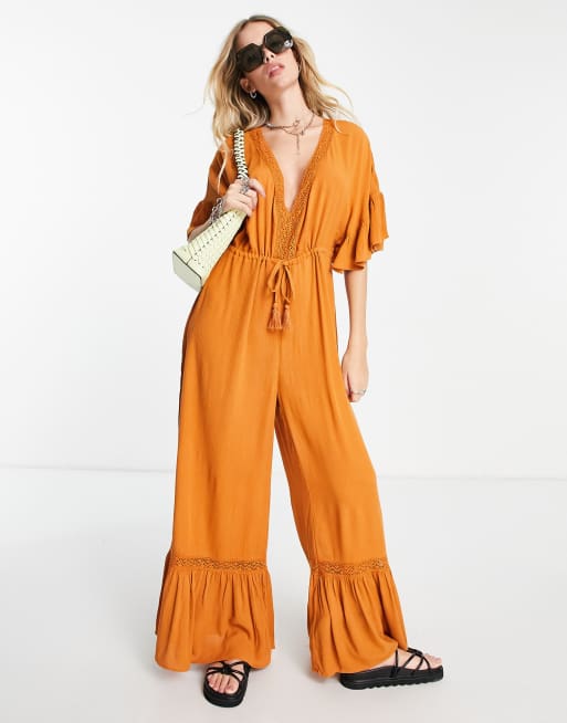 Violet Romance – Jumpsuit in goldenem Orange mit weitem Bein und Häkeleinsatz