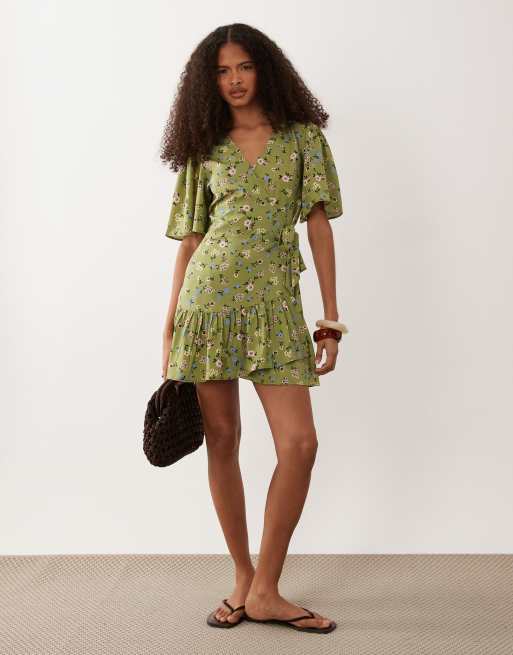 flutter sleeve mini dress Binselle True White Hibiscus and Pine Smocked back Front twist with cut out Unlined 100% Rayon Imported Model is wearing a size SmallModel #1 Profile Black Floral Cotton Mini Dress