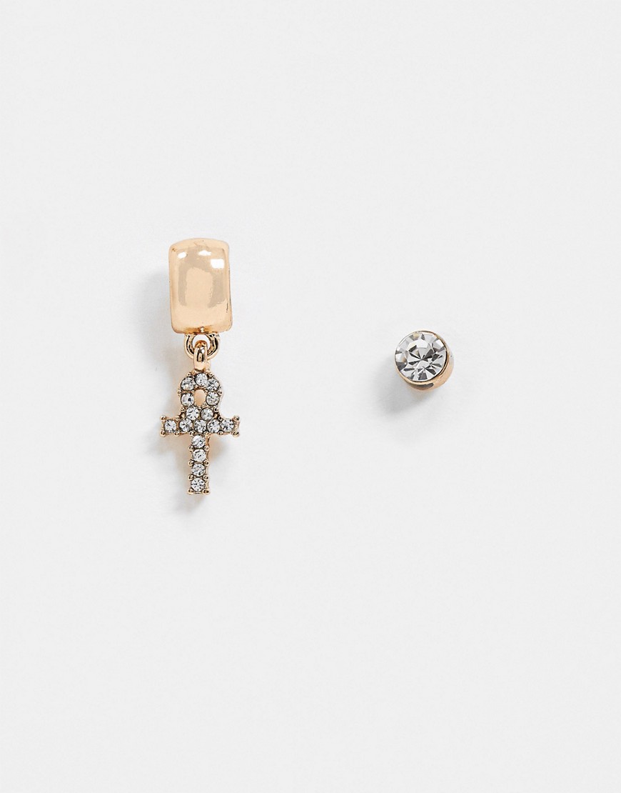 WFTW – Guldfärgade örhängen, ett med strassprydd ankh-berlock och ett i stiftdesign med sten