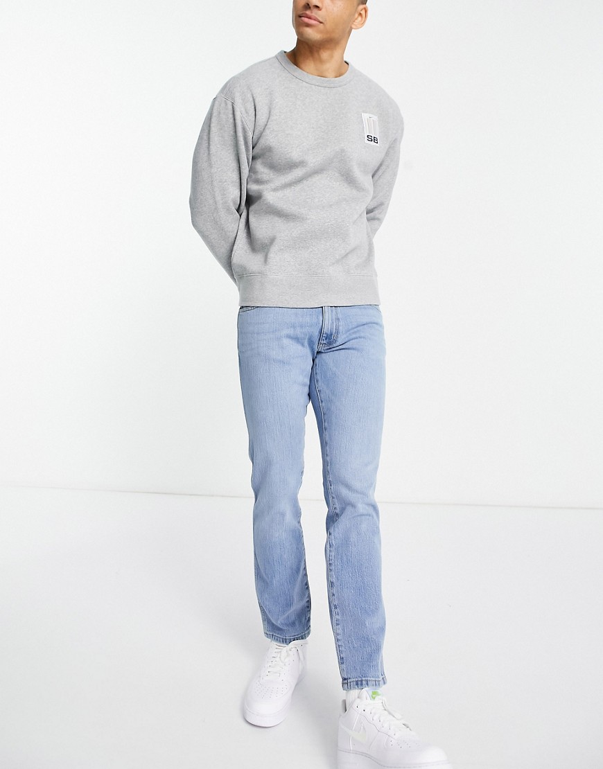 Wrangler – Larston – Mellanblå jeans med smal, avsmalnande passform