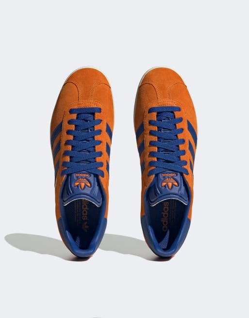 Zapatillas adidas azules store con rayas naranjas