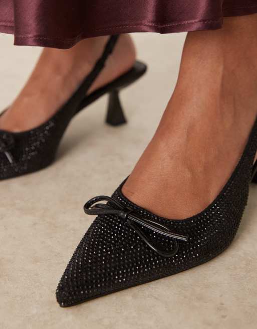 Zapatos negros destalonados de tacón bajo con lazo y pedrería de