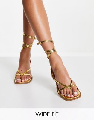 фото Золотистые сандалии на среднем каблуке для широкой стопы с перемычкой между пальцами asos design wide fit hana-золотистый